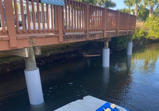 Boardwalk pilings fitted with white Snap Jacket sleeves