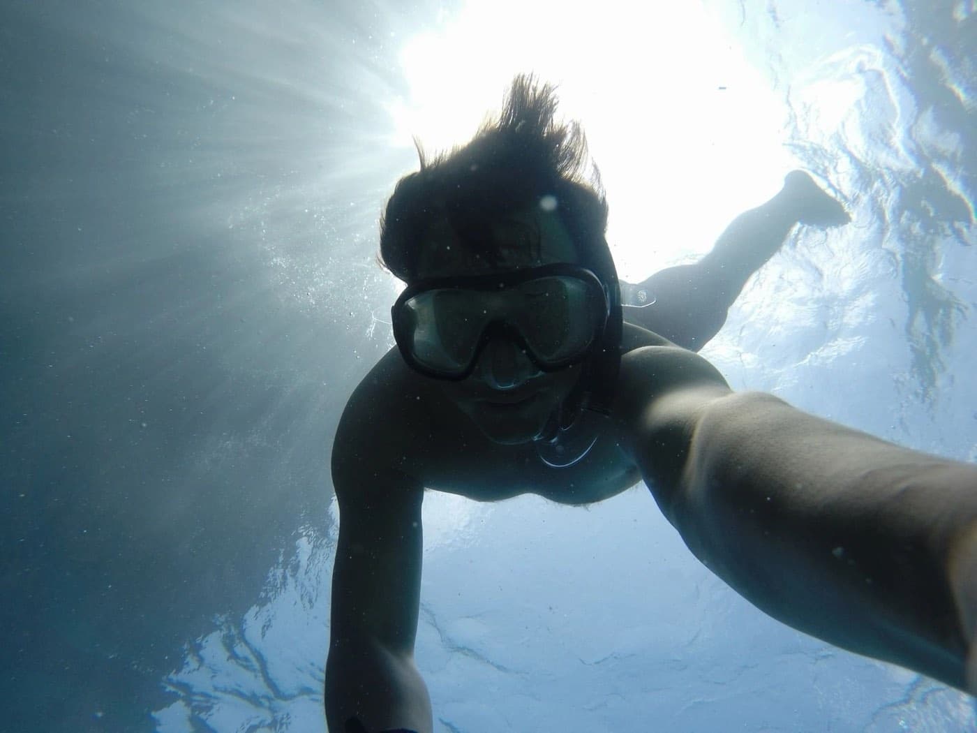 Diver swimming underwater toward the camera
