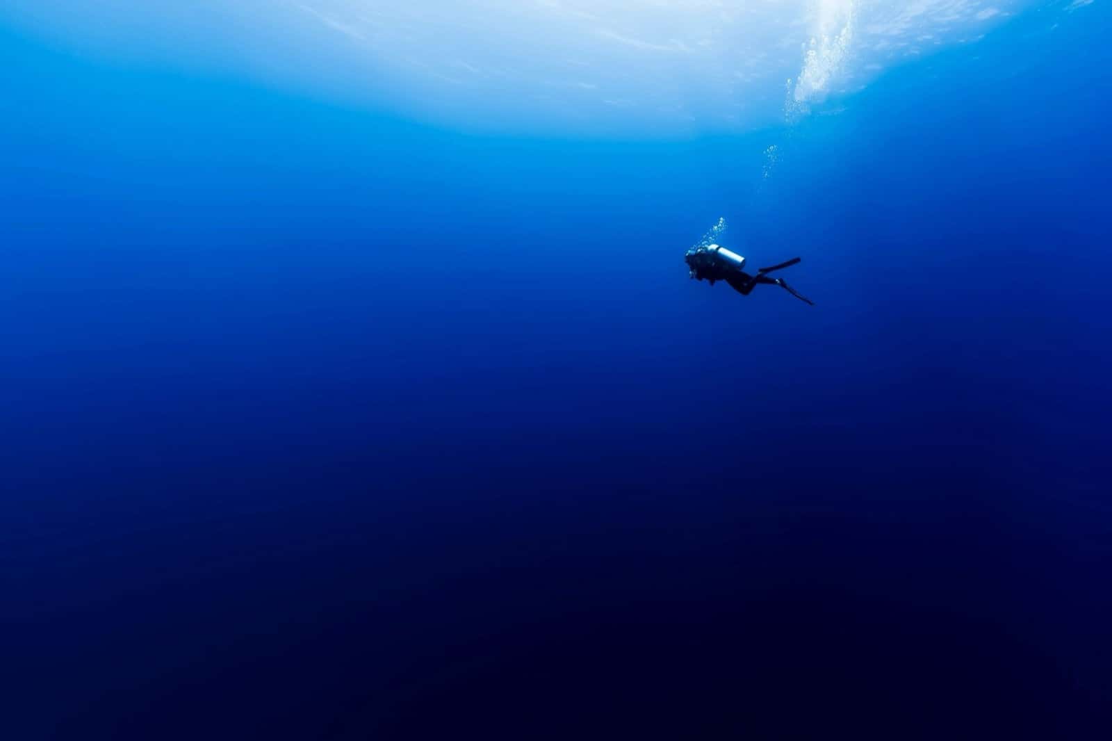 Scuba diver in deep blue open water
